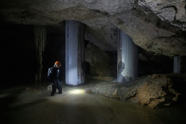 Environmental activist Roberto Rojo stands next to metal columns inside a cave supporting Mexico's controversial Maya Train (CARL DE SOUZA)
