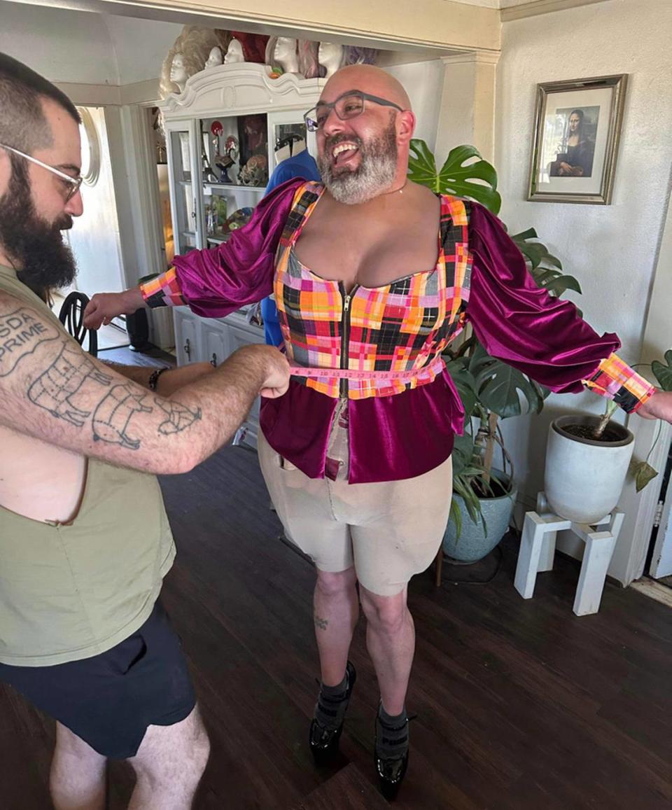 Turlock restaurant owner Jo Sisemore getting measured for his drag outfit by Larry Soria, husband of drag mentor/performer Sasha Devaroe.