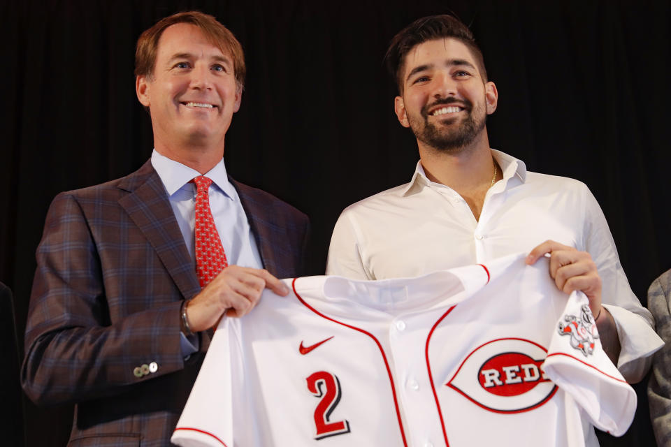 Cincinnati Reds' Nick Castellanos, right, holds his jersey alongside Reds president and director of operations Dick Williams during a news conference, Tuesday, Jan. 28, 2020, in Cincinnati. Castellanos signed a $64 million, four-year deal with the baseball club. (AP Photo/John Minchillo)