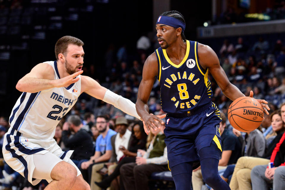 Indiana Pacers forward Justin Holiday (8) handles the ball against Memphis Grizzlies guard Marko Guduric (23) in the first half of an NBA basketball game Monday, Dec. 2, 2019, in Memphis, Tenn. (AP Photo/Brandon Dill)