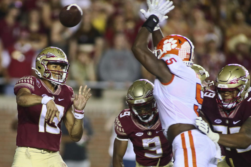 Florida State quarterback Jordan Travis (13) is pressured by Clemson defensive end K.J. Henry (5) into throwing an incomplete pass during the fourth quarter of an NCAA college football game Saturday, Oct. 15, 2022, in Tallahassee, Fla. Clemson won 34-28. (AP Photo/Phil Sears)