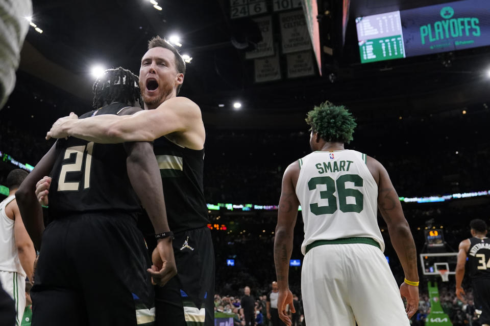 Milwaukee Bucks guard Jrue Holiday (21) is embraced by Pat Connaughton while celebrating after blocking a shot by Boston Celtics guard Marcus Smart (36) in the final seconds of play during the second half of Game 5 of an Eastern Conference semifinal in the NBA basketball playoffs, Wednesday, May 11, 2022, in Boston. The Bucks won 110-107. (AP Photo/Charles Krupa)