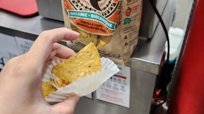 Person holding tortilla chip sample