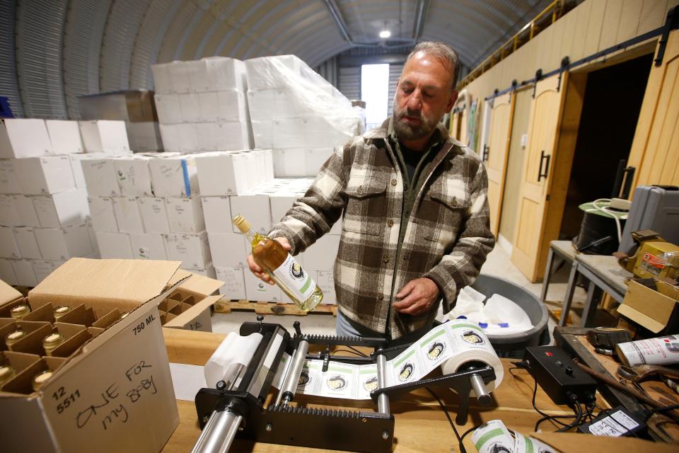 Nicholas Christy puts a label on a bottle of pink Reisling wine at the Nasketucket Bay Vineyard on New Boston Road in Fairhaven