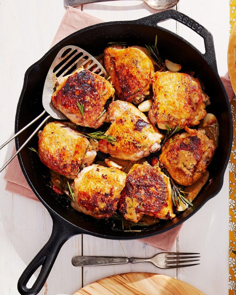 rispy chicken thighs with garlic and rosemary in a cast iron skillet