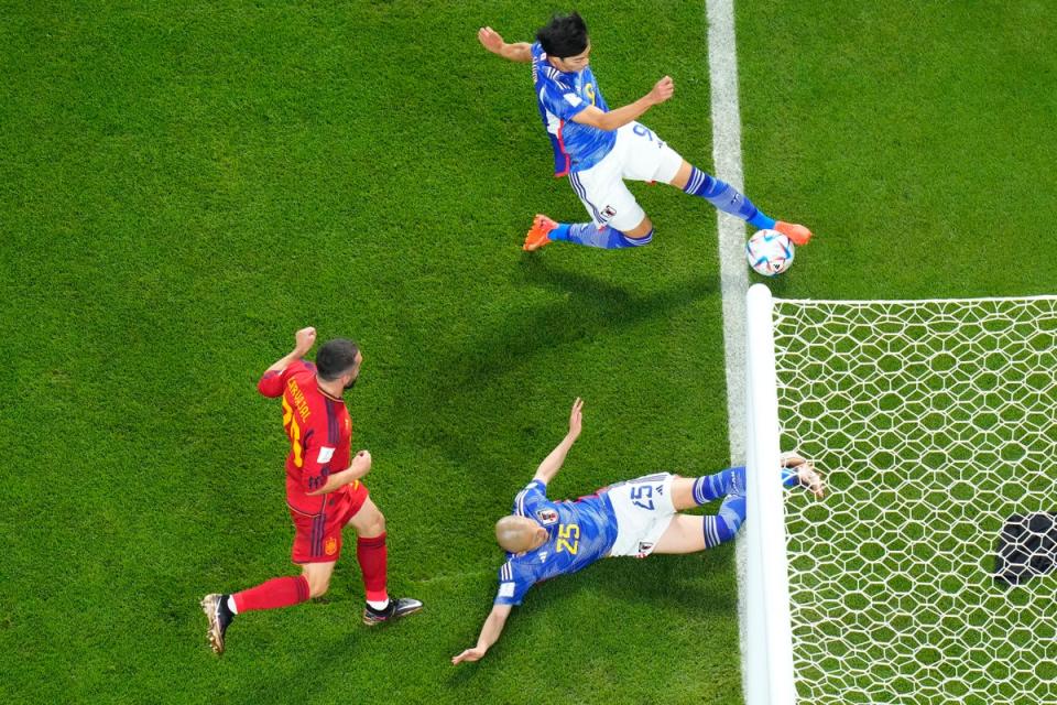 Japan’s Kaoru Mitoma appears to have the ball over the line before crossing it for a goal during the World Cup group E soccer match between Japan and Spain, at the Khalifa International Stadium in Doha, Qatar (AP)