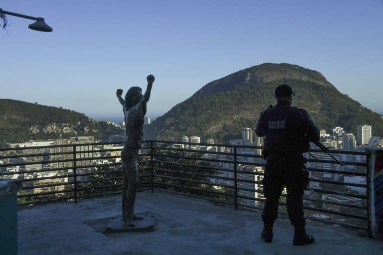 A police officer stands guard next to famous statue of the King of Pop, Michael Jackson, in the Santa Marta favela in Rio de Janeiro