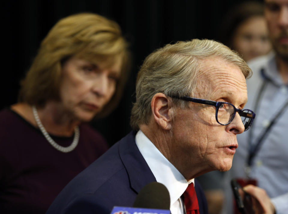 Ohio Attorney General and Republican gubernatorial candidate Mike DeWine answers reporters' questions in the spin room as his wife, Fran, listens following a debate with Democratic gubernatorial candidate Richard Cordray at Marietta College in Marietta, Ohio, Monday, Oct. 1, 2018. (AP Photo/Paul Vernon)