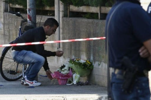 A man places flowers on the site of a blast near a school in Brindisi. Italy was in shock on Saturday after an unexplained bombing at a school killed a 16-year-old girl and left five other teens gravely injured, sparking emotional protests across the country