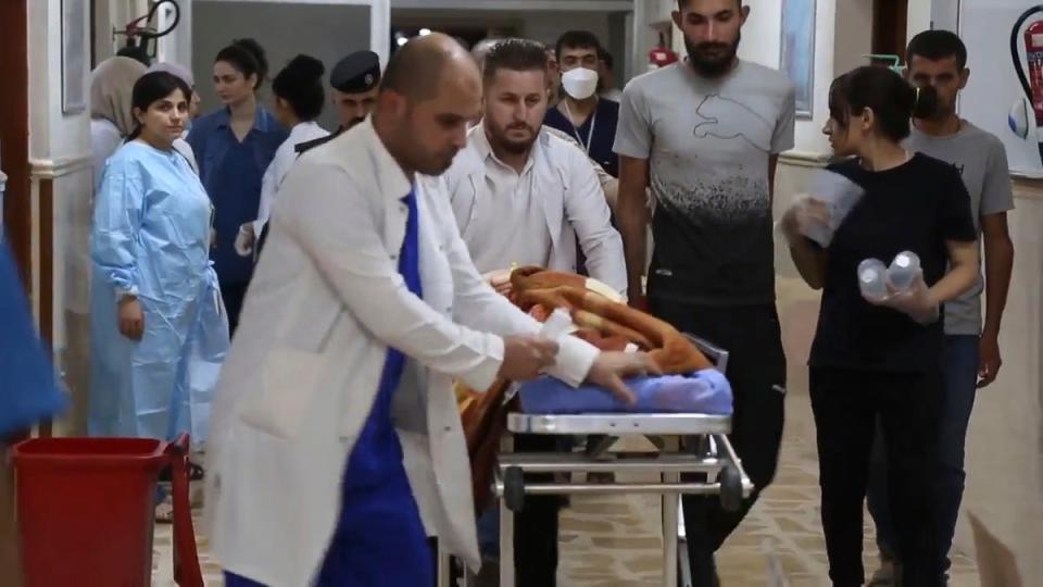This image made from video shows medical staff taking an injured person inside a hospital in Hamdaniya, Nineveh province, Iraq, Wednesday, 27 September 2023 (AP)