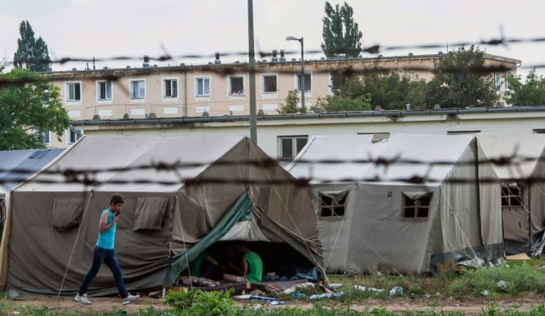 A refugee walks past a tent in a camp in Debrecen, Hungary on June 30, 2015