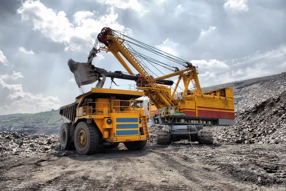 An excavator loading a dump truck in an open-pit mine.