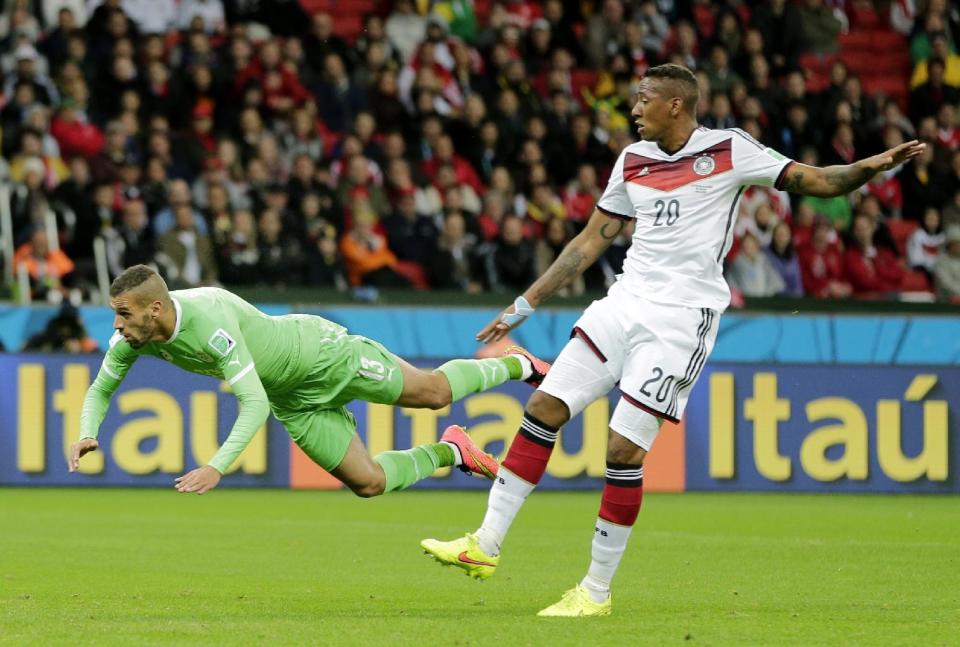 Algeria's Islam Slimani, left, is airborne in front of Germany's Jerome Boateng after heading the ball during the World Cup round of 16 soccer match between Germany and Algeria at the Estadio Beira-Rio in Porto Alegre, Brazil, Monday, June 30, 2014. (AP Photo/Matthias Schrader)