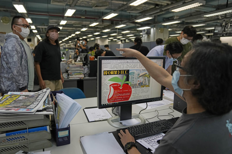 Workers design the layout of Apple Daily newspaper at the printing house in Hong Kong, early Friday, June 18, 2021. Five editors and executives at pro-democracy Apple Daily newspaper were arrested Thursday under Hong Kong's national security law, its stock was halted and police were searching its offices in moves raising concerns about the media's future in the city. (AP Photo/Kin Cheung)