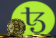 Photo illustration shows copies of Bitcoins seen in front of Tezos logo, October 10, 2017. Picture taken October 10, 2017. REUTERS/Dado Ruvic/lllustratio