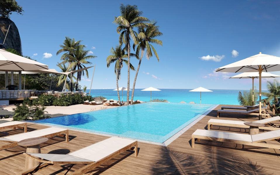 White lounge chairs are lined up around an infinity pool at Silversands hotel in Grenada