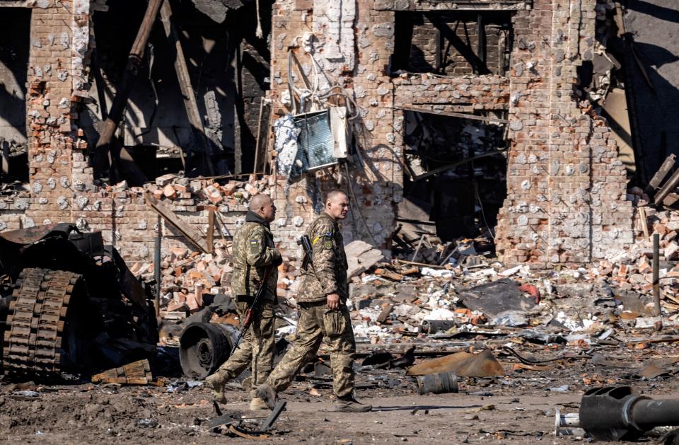 TOPSHOT - Ukrainian servicemen walk amid rubble near a destroyed building in the northeastern city of Trostyanets', on March 29, 2022. - Ukraine said on March 26, 2022 its forces had recaptured the town of Trostianets, near the Russian border, one of the first towns to fall under Moscow's control in its month-long invasion. (Photo by FADEL SENNA / AFP) (Photo by FADEL SENNA/AFP via Getty Images)