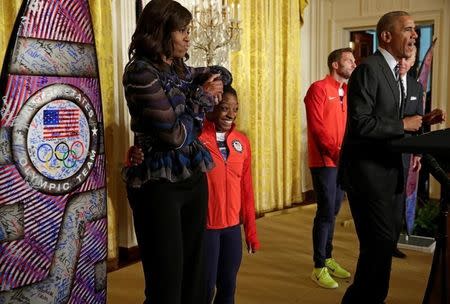 2016 Olympic individual all-around gymnast Simone Arianne Biles hugs First lady Michelle Obama as U.S. President Barack Obama speaks to U.S. Olympic and Paralympics teams at the White House in Washington, U.S., September 29, 2016. REUTERS/Yuri Gripas