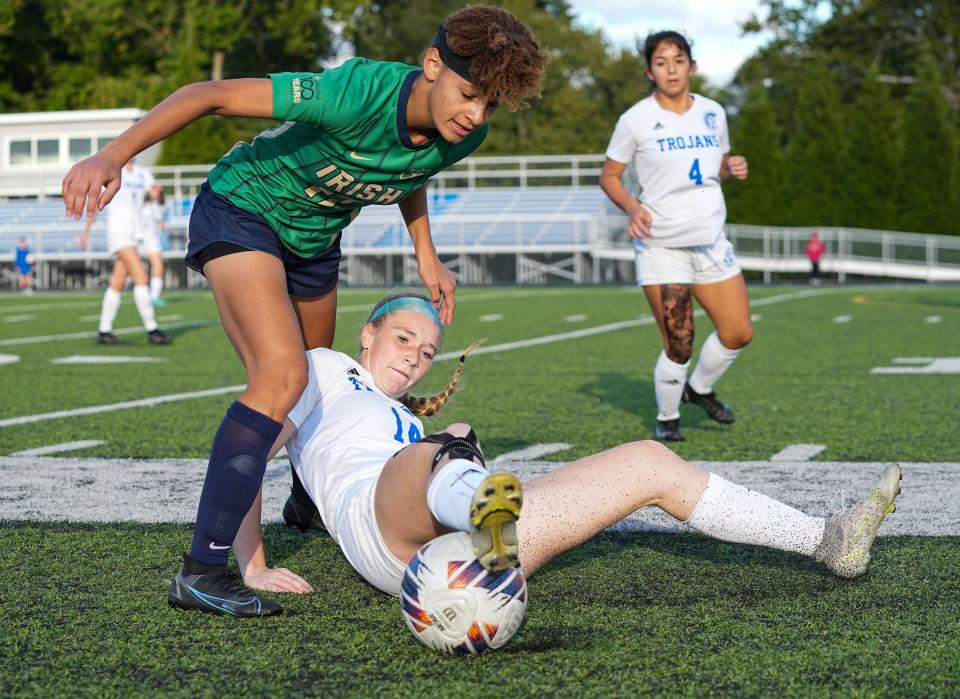 Bishop Chatard Trojans defender Kate Sedlak (14) slides for the ball against Cathedral Fighting Irish Keira Bradford (17) on Wednesday, Sept. 28, 2022, at Bishop Chatard High School in Indianapolis.  