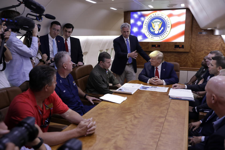 President Donald Trump participates in a briefing with North Carolina Gov. Roy Cooper, left, and House Minority Leader Kevin McCarthy of Calif., standing center, about Hurricane Dorian at Marine Corps Air Station Cherry Point, Monday, Sept. 9, 2019, in Havelock, N.C., aboard Air Force One. (AP Photo/Evan Vucci)