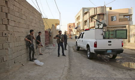 Sunni tribal fighters and Iraqi police carry their weapons as they stand guard against attacks from Islamic State militants, in Ramadi, May 15, 2015. REUTERS/Stringer