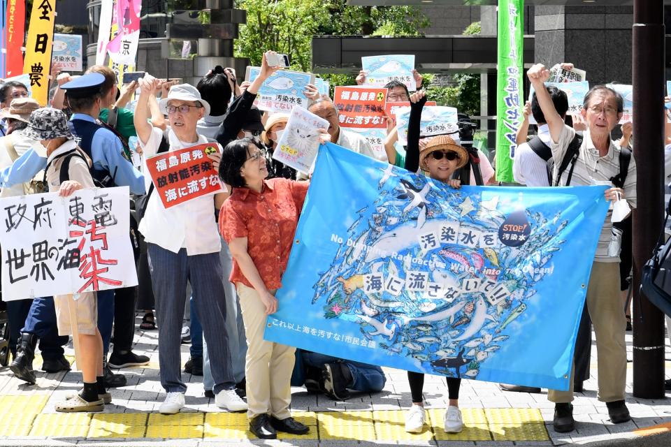 Protester holds a sign during a rally against the treated radioactive water release from the damaged Fukushima nuclear power plant, in front of Tokyo Electric Power Company Holdings (TEPCO) headquarters, Thursday, Aug. 24, 2023, in Tokyo.