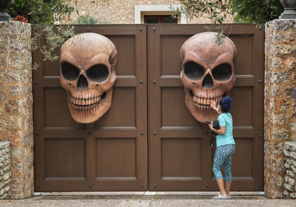 Liz Johnson gets a closer look at Halloween decorations at the entrance to a home on Crescenda St. in Brentwood.