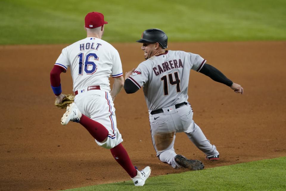 Texas Rangers third baseman Brock Holt runs down Arizona Diamondbacks' Asdrubal Cabrera, who was trying to advance to third on a sacrifice fly by David Peralta in the fourth inning of a baseball game in Arlington, Texas, Tuesday, July 27, 2021. Christian Walker scored. (AP Photo/Tony Gutierrez)