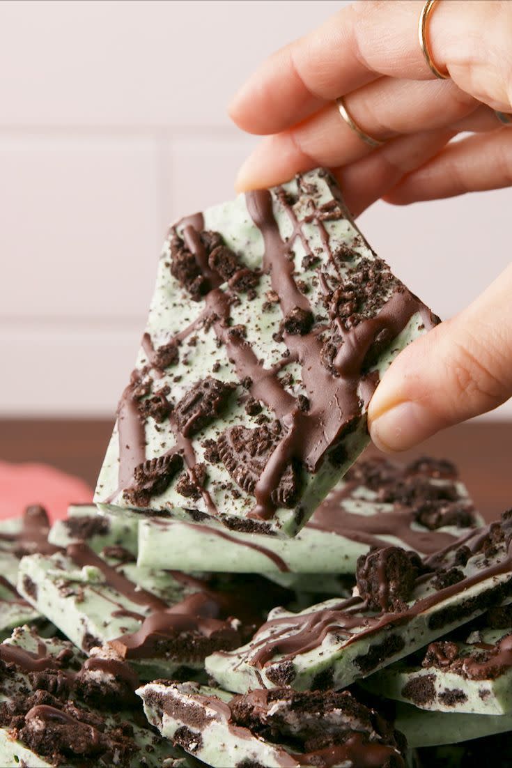 a person holding a piece of mint oreo bark