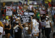 A woman wearing a protective face mask holds a sign with a message that reads in Portuguese; "500 k deaths! His fault!" during a protest against Brazilian President Jair Bolsonaro's handling of the coronavirus pandemic and economic policies they say harm the interests of the poor and working class, in Rio de Janeiro, Brazil, Saturday, June 19, 2021. Brazil is approaching an official COVID-19 death toll of 500,000 — second-highest in the world. (AP Photo/Bruna Prado)