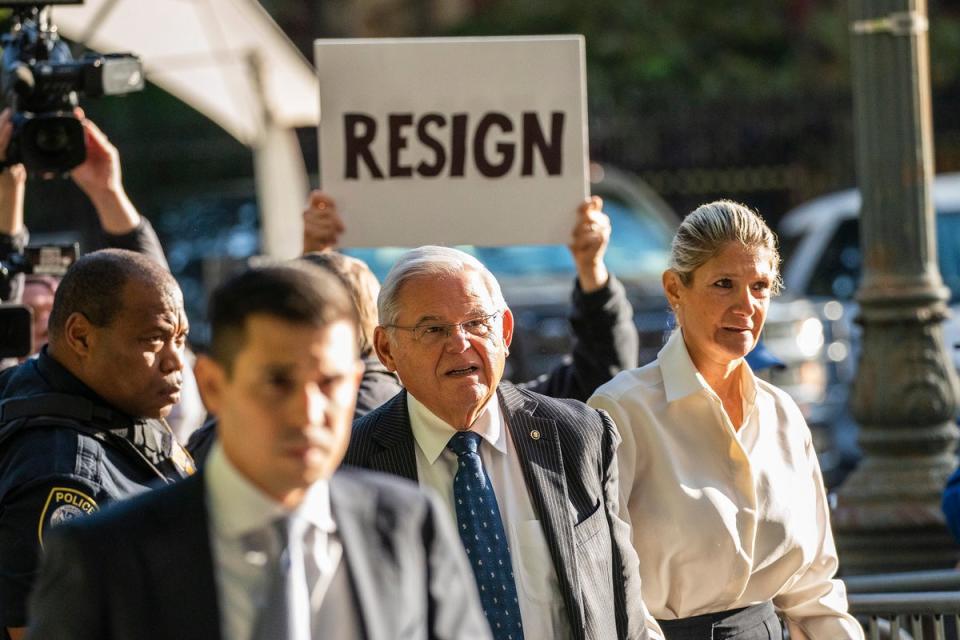 A protester holds a sign calling for US Senator Robert Menendez to resign as he enters federal court in New York City on 27 September. (EPA)