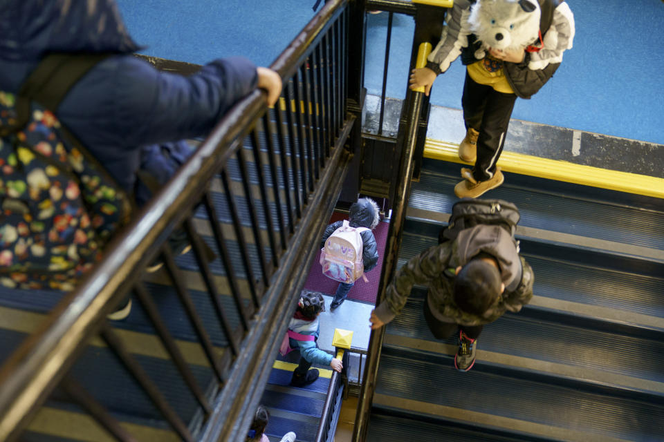FILE - Students exit through a stairwell during dismissal at Raices Dual Language Academy, a public school in Central Falls, R.I., Feb. 9, 2022. U.S. COVID-19 cases are up, leading a smattering of school districts, particularly in the Northeast, to bring back mask mandates and recommendations for the first time since the omicron winter surge ended and as the country approaches 1 million deaths in the pandemic. (AP Photo/David Goldman, File)