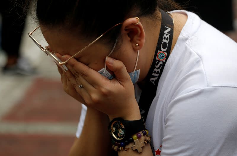 An ABS-CBN employee cries after the Philippine congress voted against the renewal of the broadcast network's 25-year franchise, outside ABS-CBN headquarters, in Quezon City