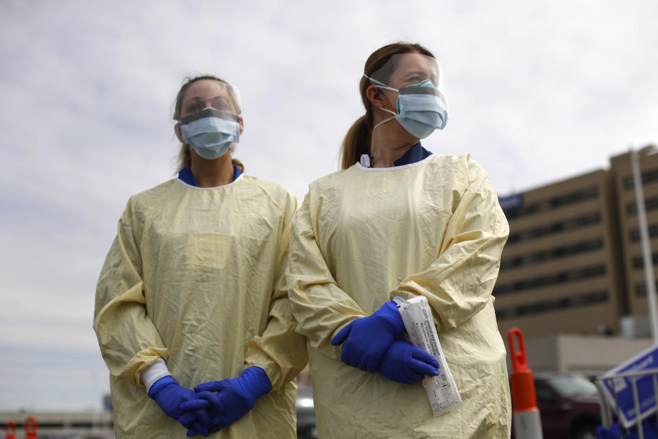 Physicians Assistant Jessica Hamilton, left, and Amena Beslic RN holds a swab and test tube kit to test people for COVID-19 at a drive through station set up in the parking lot of the Beaumont Hospital in Royal Oak, Mich., Monday, March 16, 2020. (AP Photo/Paul Sancya)