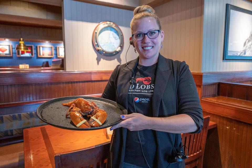 Pueblo Red Lobster General Manager Kendra Kastendieck shows off "Crush" the rare orange lobster that was found in a live shipment to the restaurant.