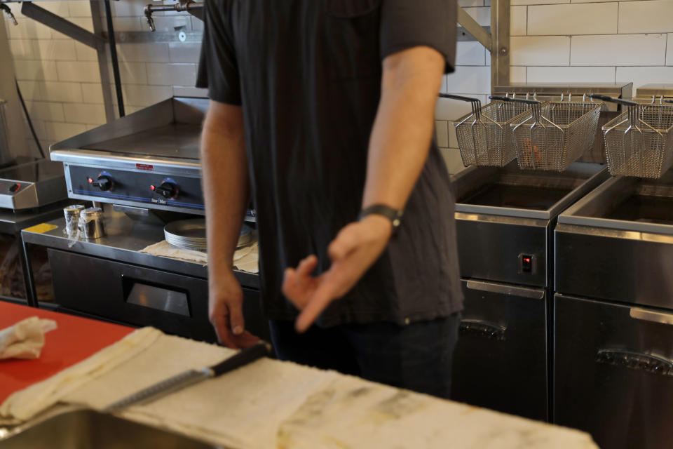 In this Thursday, Sept. 12, 2019 photo, Chris Miles points out some electric appliances at his restaurant, Batesy's, in the Rockaway section of New York. National Grid has imposed a moratorium on new gas hookups in parts of New York City, saying it can’t meet rising demand without the new pipeline. The showdown has hurt people like Miles, whose new barbecue restaurant in Rockaway Beach missed the summer season after it was denied a new gas hookup. (AP Photo/Seth Wenig)