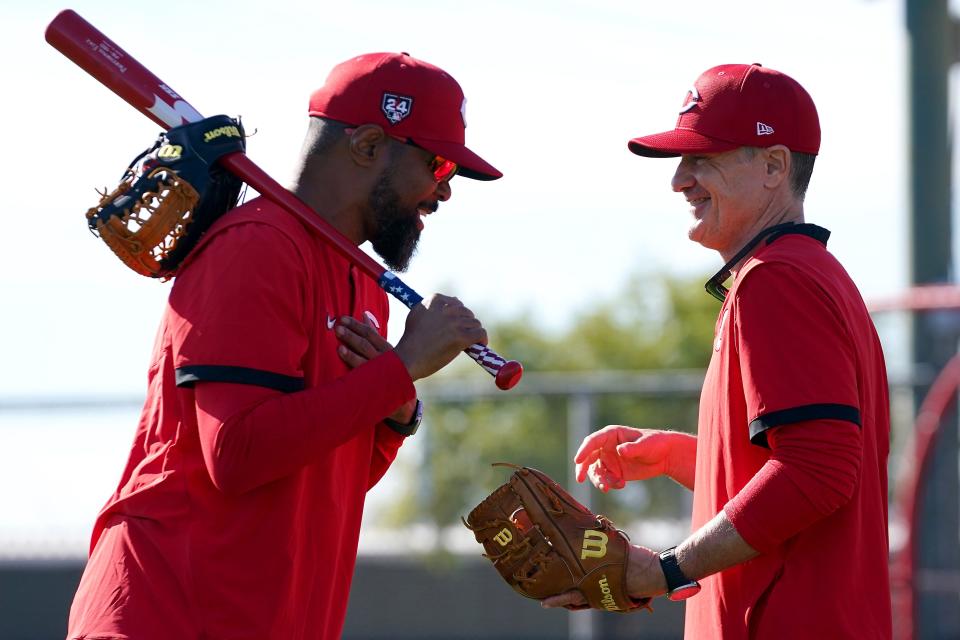 Reds manager David Bell, here chatting with special assistant Barry Larkin, is confident he can make the team's "roster math" add up.