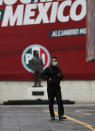 A security guard stands inside the closed headquarters of the Institutional Revolutionary Party of Mexico, PRI, in Mexico City, on Wednesday, June 30, 2021. The doors were closed after party dissidents set up a ring of protesters Tuesday around the headquarters and fighting apparently broke out when a squad of loyalists tried to retake the building. (AP Photo/Marco Ugarte)