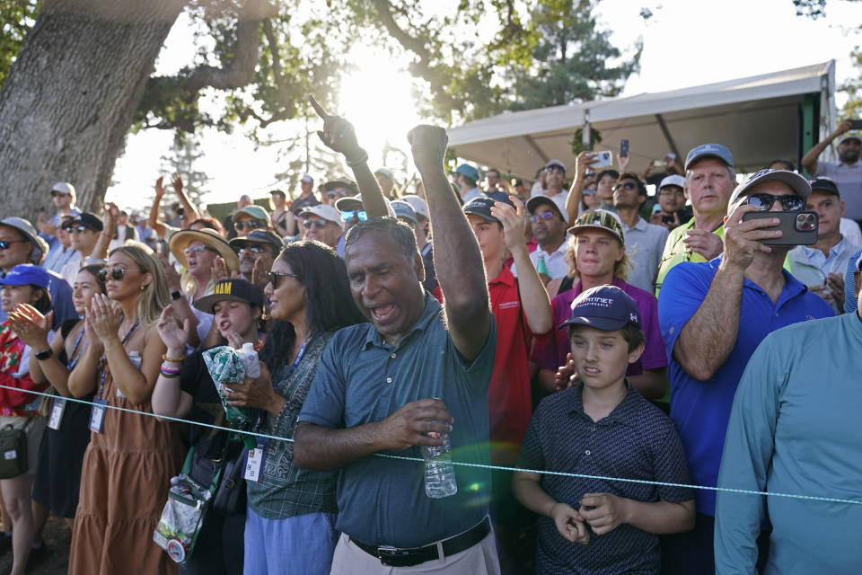 Muralidhar Theegala, center, cheers on his son Sahith Theegala on the 17th green of the Silverado Resort North Course during the final round of the Fortinet Championship PGA golf tournament in Napa, Calif., Sunday, Sept. 17, 2023. (AP Photo/Eric Risberg)