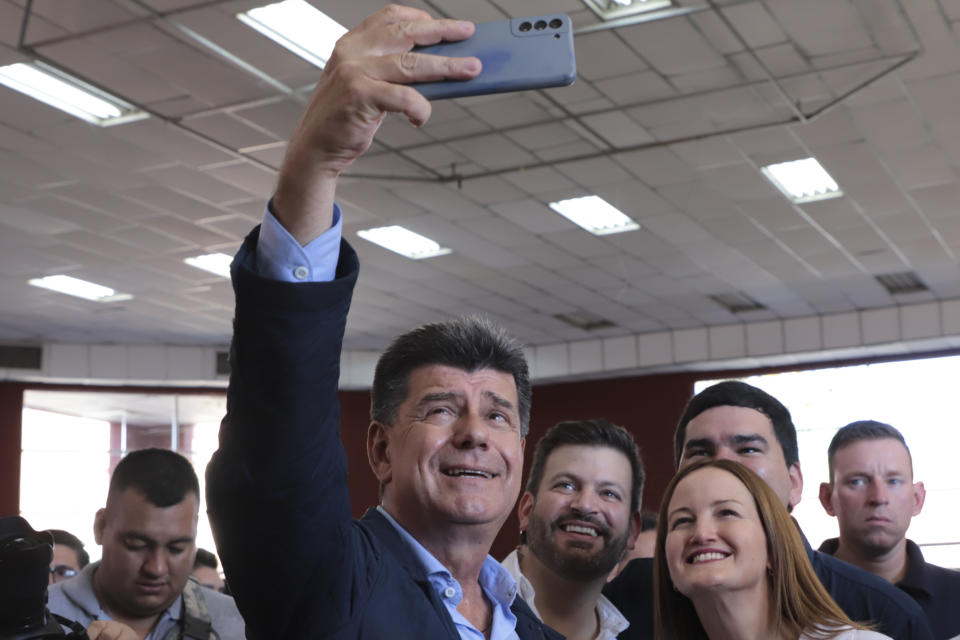 Efrain Alegre, presidential candidate for the Concertacion coalition, takes a selfie with running mate Soledad Nunez at a polling station during general elections in Lambare, outskirts Asuncion, Sunday, April 30, 2023. (AP Photo/Marta Escurra)