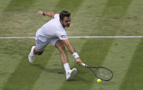 Switzerland's Stan Wawrinka returns in his Men's singles match against United States' Reilly Opelka during day three of the Wimbledon Tennis Championships in London, Wednesday, July 3, 2019. (AP Photo/Ben Curtis)