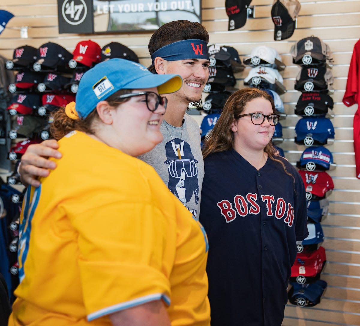 Popular WooSox player Ryan Fitzgerald poses for a shot Saturday with lucky fans in the team's pro shop.