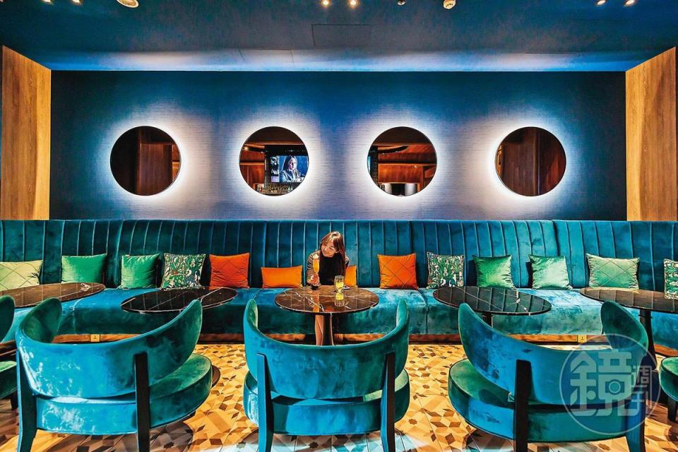 酒吧內的藍色調沙發與圓形鏡面， 讓人像是待在深海裡小酌。
