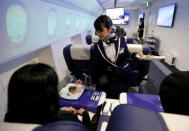 A staff dressed as flight attendant, serves appetizers to guests at the "First Airlines", virtual first-class airline experience facility in Tokyo, Japan February 14, 2018. Picture taken February 14, 2018. REUTERS/Toru Hanai