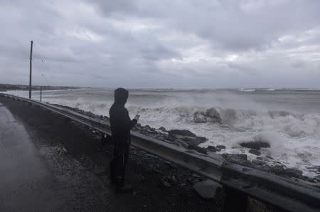 A man films storm surge from the Atlantic Ocean during Storm Grayson in Halifax, Nova Scotia, Canada January 5, 2018. REUTERS/Darren Calabrese