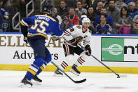 Chicago Blackhawks' Jonathan Toews (19) handless the puck as St. Louis Blues' Colton Parayko (55) defends during the first period of an NHL hockey game Tuesday Feb. 25, 2020, in St. Louis. (AP Photo/Scott Kane)