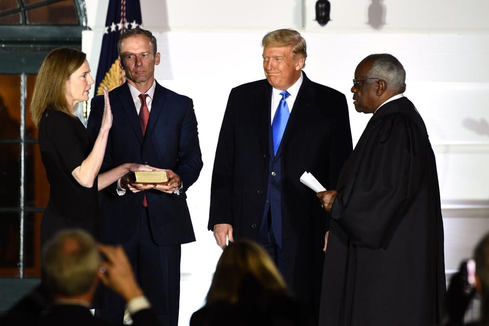 President Donald Trump watches as Supreme Court Justice Clarence Thomas swears in Justice Amy Coney Barrett on Oct. 26, 2020.