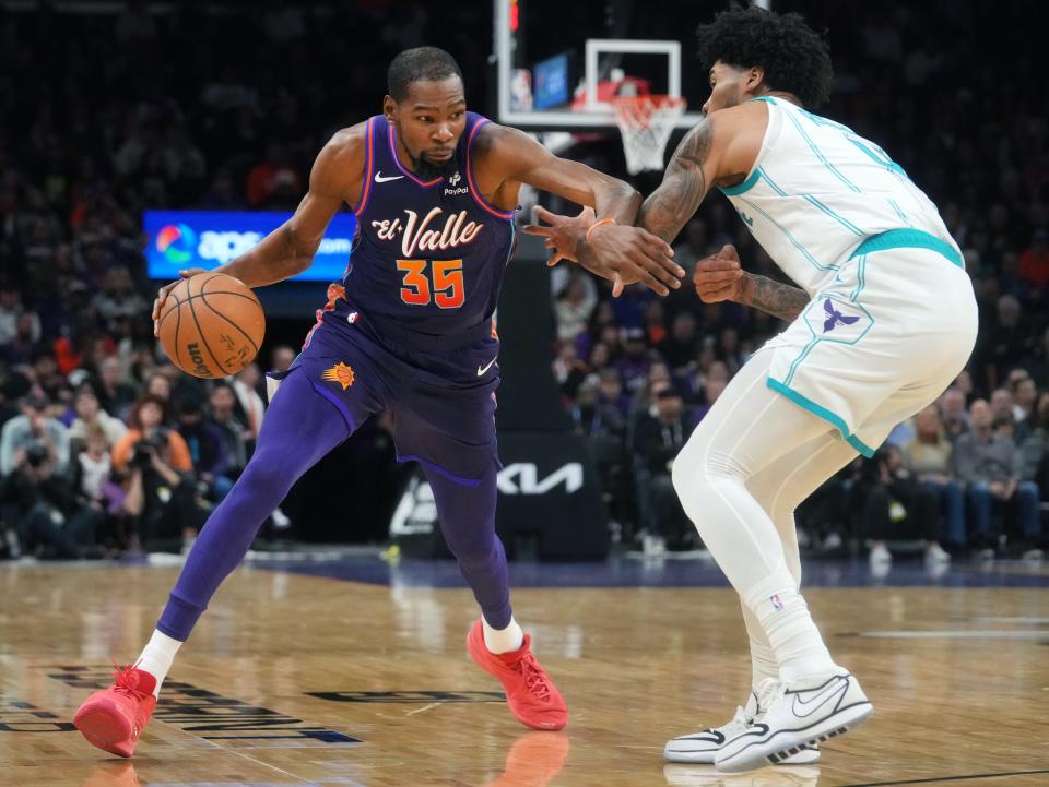 Phoenix Suns forward Kevin Durant (35) drives past Charlotte Hornets center Nick Richards (4) at Footprint Center in Phoenix on Dec. 29, 2023.