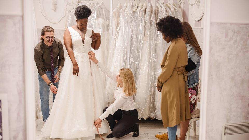 Designer making adjustment to bridal gown