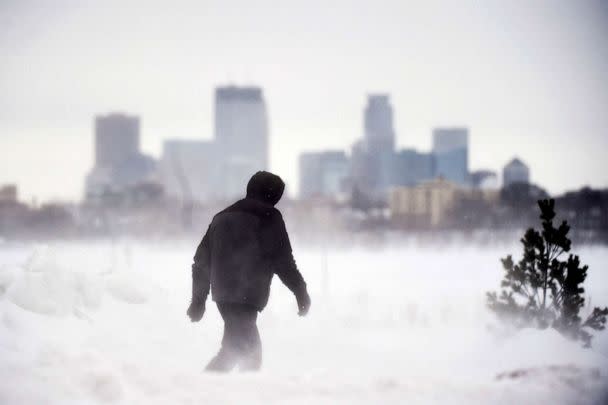 PHOTO: A man goes for a walk in front of the Minneapolis skyline at Bde Maka Ska Park during a snowstorm in Minneapolis, Feb. 22, 2023. (Craig Lassig/AFP via Getty Images)